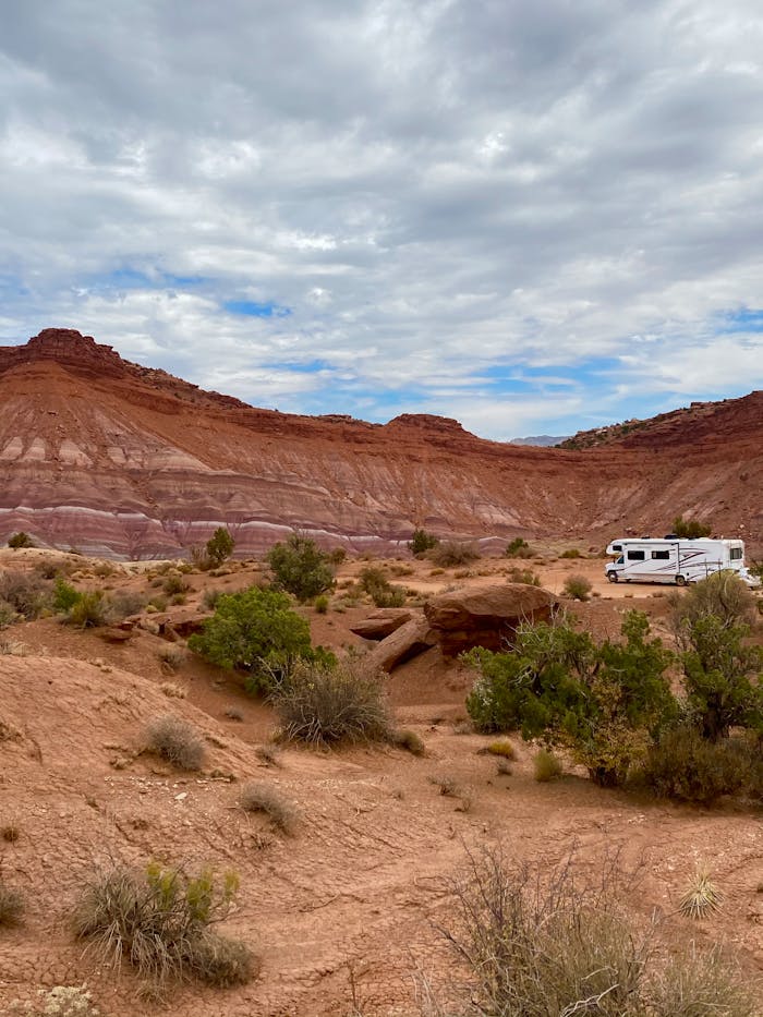our-story-02 Campervan parked in a stunning Utah desert landscape with red rock formations.