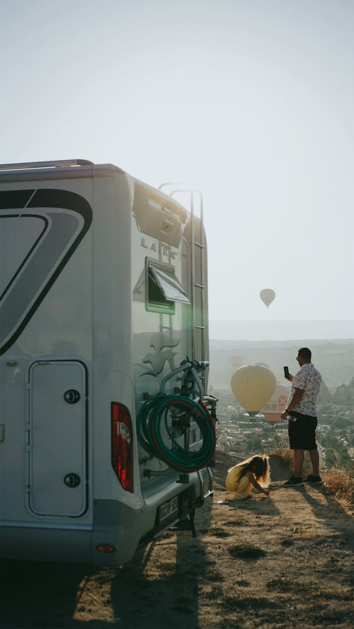 The Art of Drawing Readers In: Your attractive post title goes here A man and child enjoying hot air balloons from an RV in scenic Cappadocia, Türkiye.